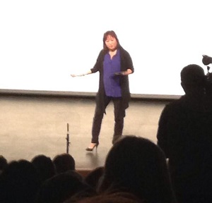 Woman speaking at conference in front of audience.